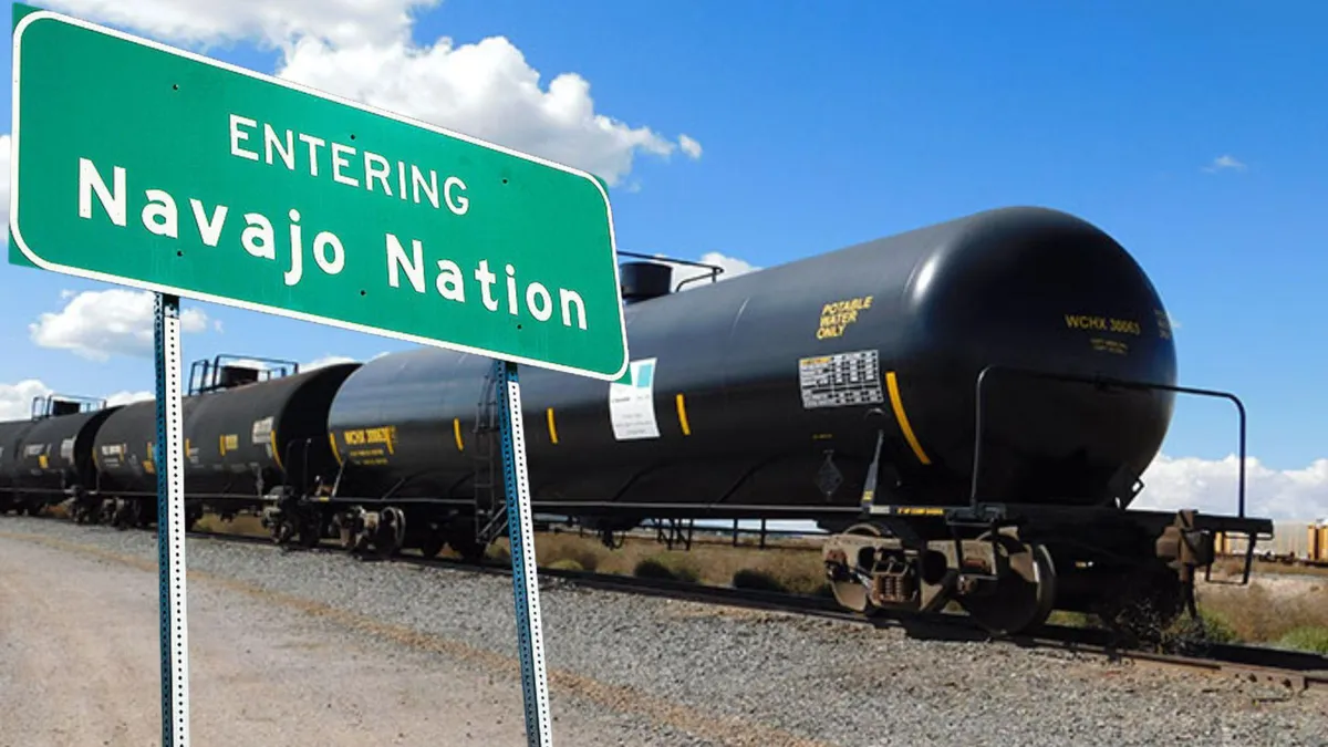 A black train car that brings drinking water across the county/A green road sign that reads “Entering Navajo Nation”