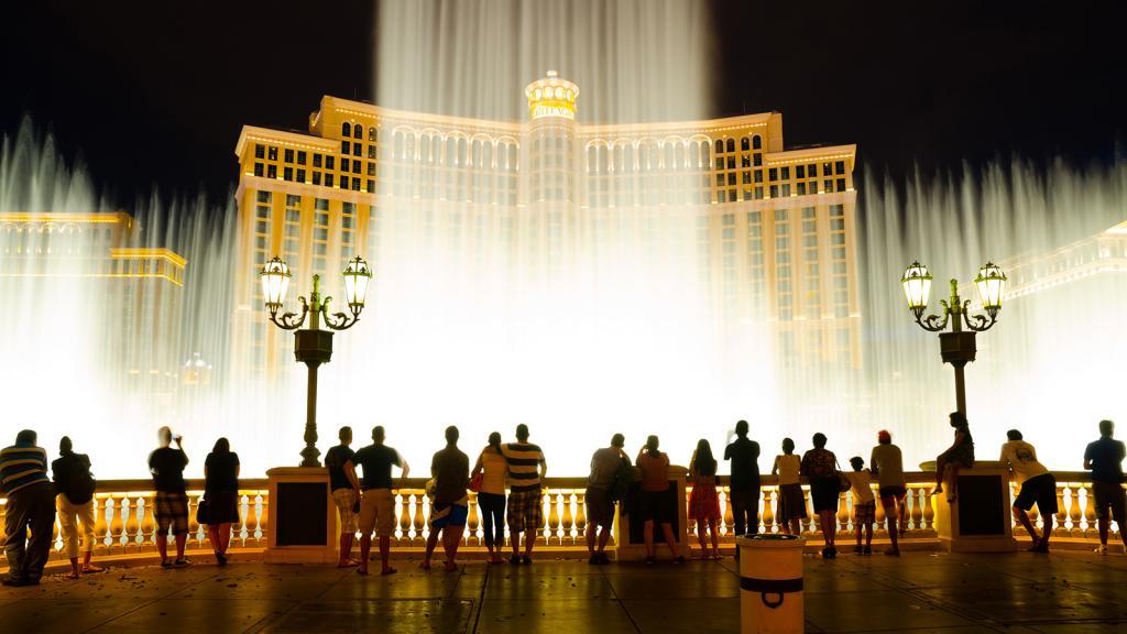 Fountains outside an illuminated hotel; archive photograph.