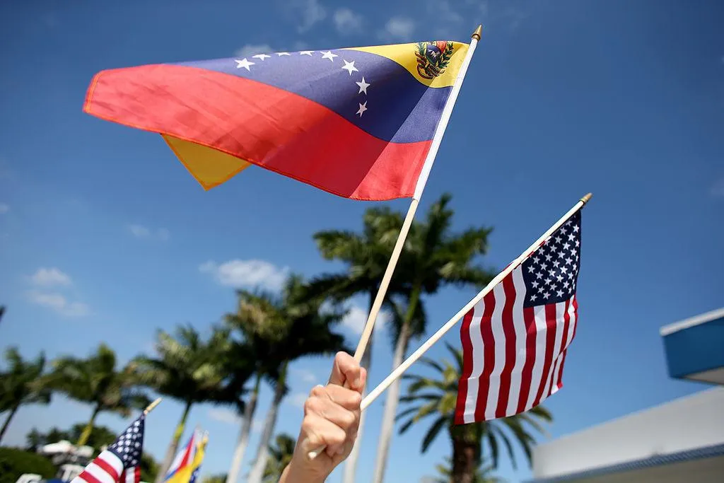 A protester holds a Venezuelan and American flag as she and other Venezuelans and their supporters show their support for the anti-government protests in Venezuela