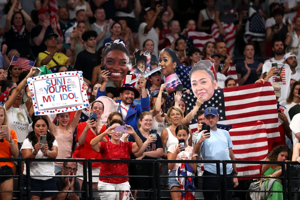 PARIS, FRANCE - JULY 30: Fans of Team United States cheer and hold signs during the Artistic Gymnastics Women's Team Final on day four of the Olympic Games Paris 2024 at Bercy Arena on July 30, 2024 in Paris, France.