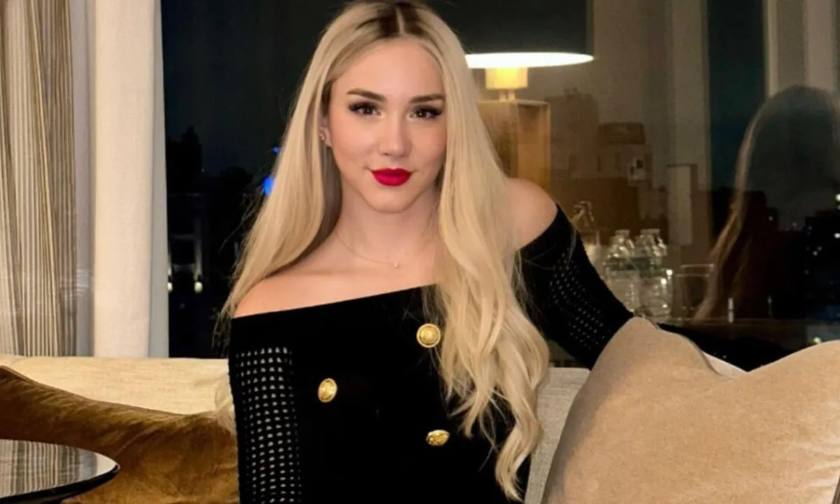 Mikhaila Peterson poses for a photo wearing a black sweater as she sits on a chair