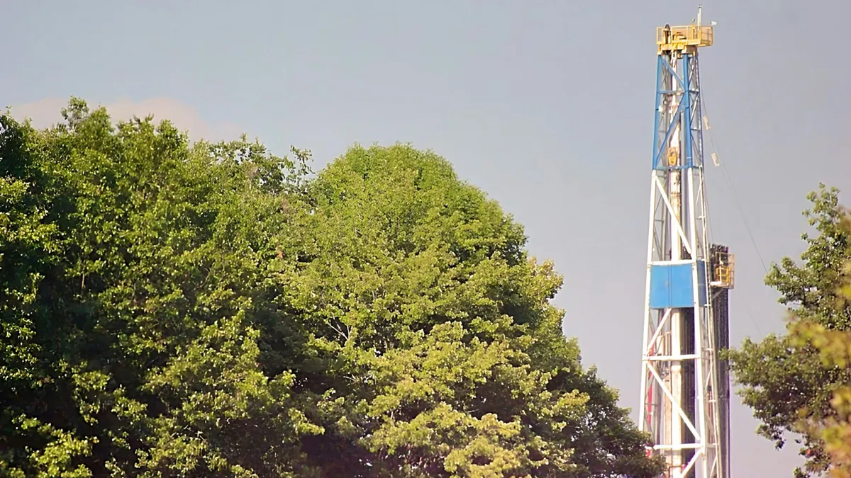 A large white and blue tower next to large green trees