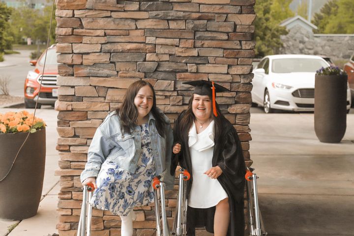 The sisters wearing graduation caps and gowns