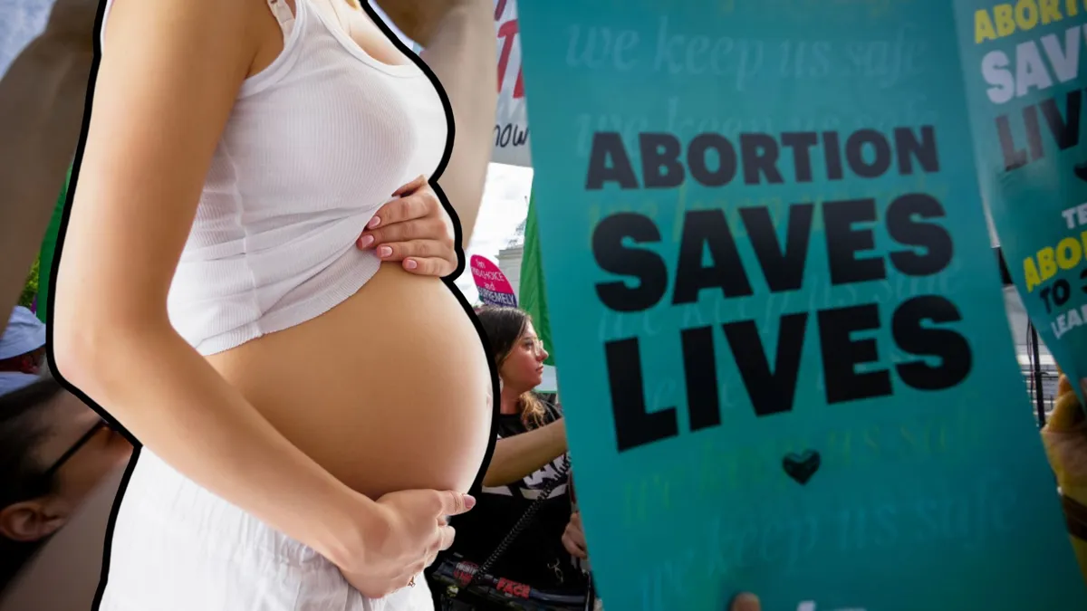 A pregnant woman next to a sign that reads 'Abortion saves lives'