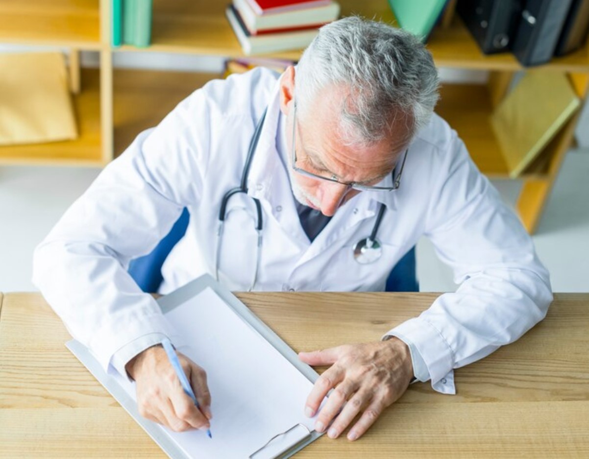 Illustrative stock photograph of a healthcare professional reviewing paperwork.