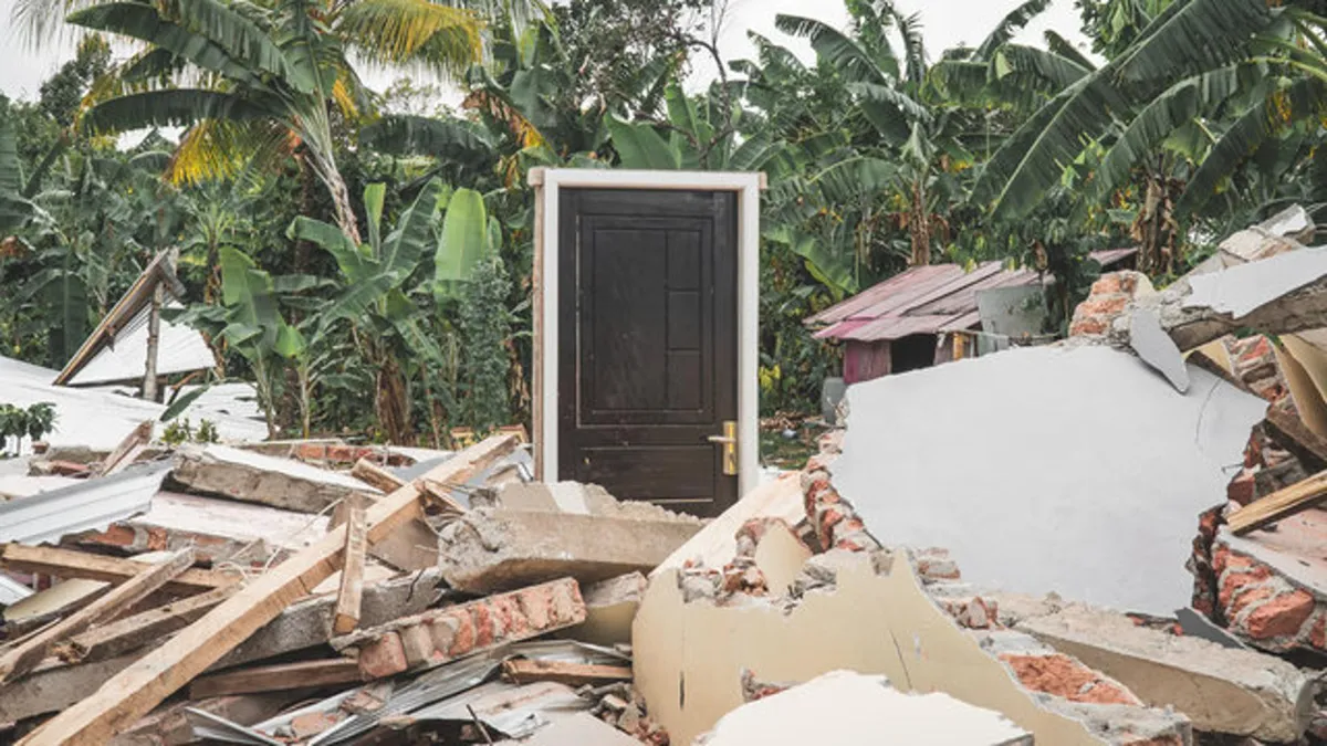 Rubble surrounds a doorway after an earthquake