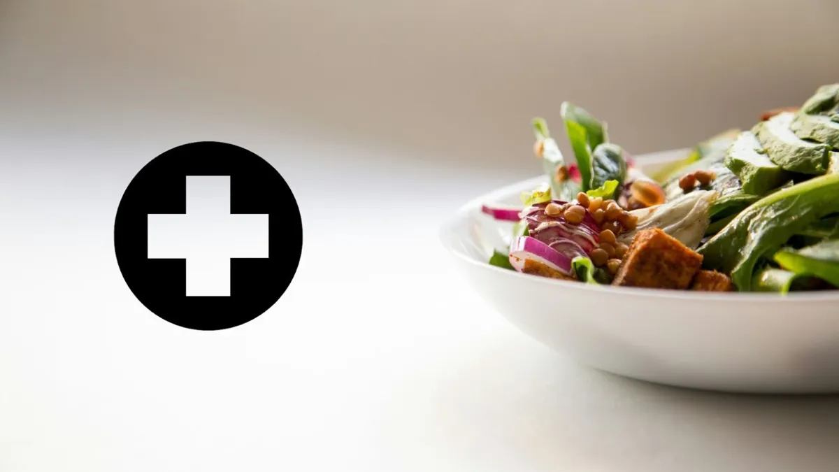 A close-up of a health icon beside a bowl of healthy food against a white background.