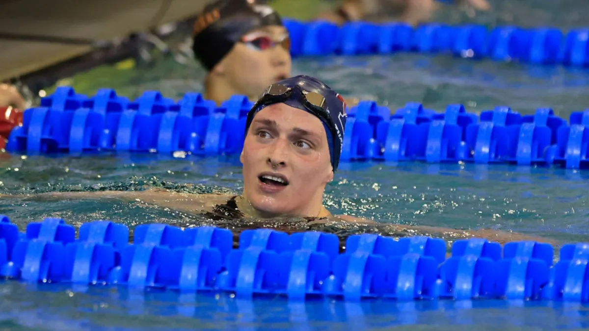 A swimmer treading water between blue dividers in a large pool