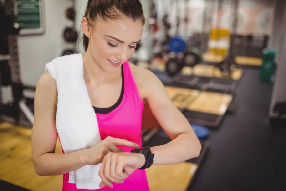 Woman checking her watch while working out at the gym