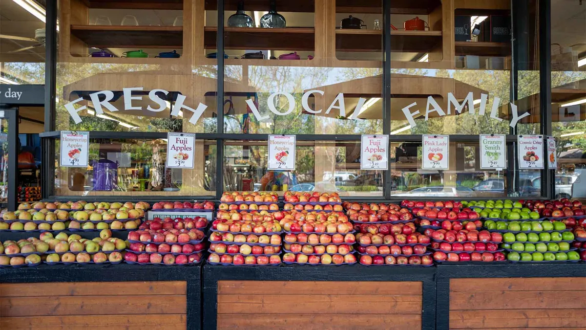 Apples are stacked outside Diablo Foods, a family owned grocery store in Lafayette, California, with words Fresh, Local and Family visible on a window above