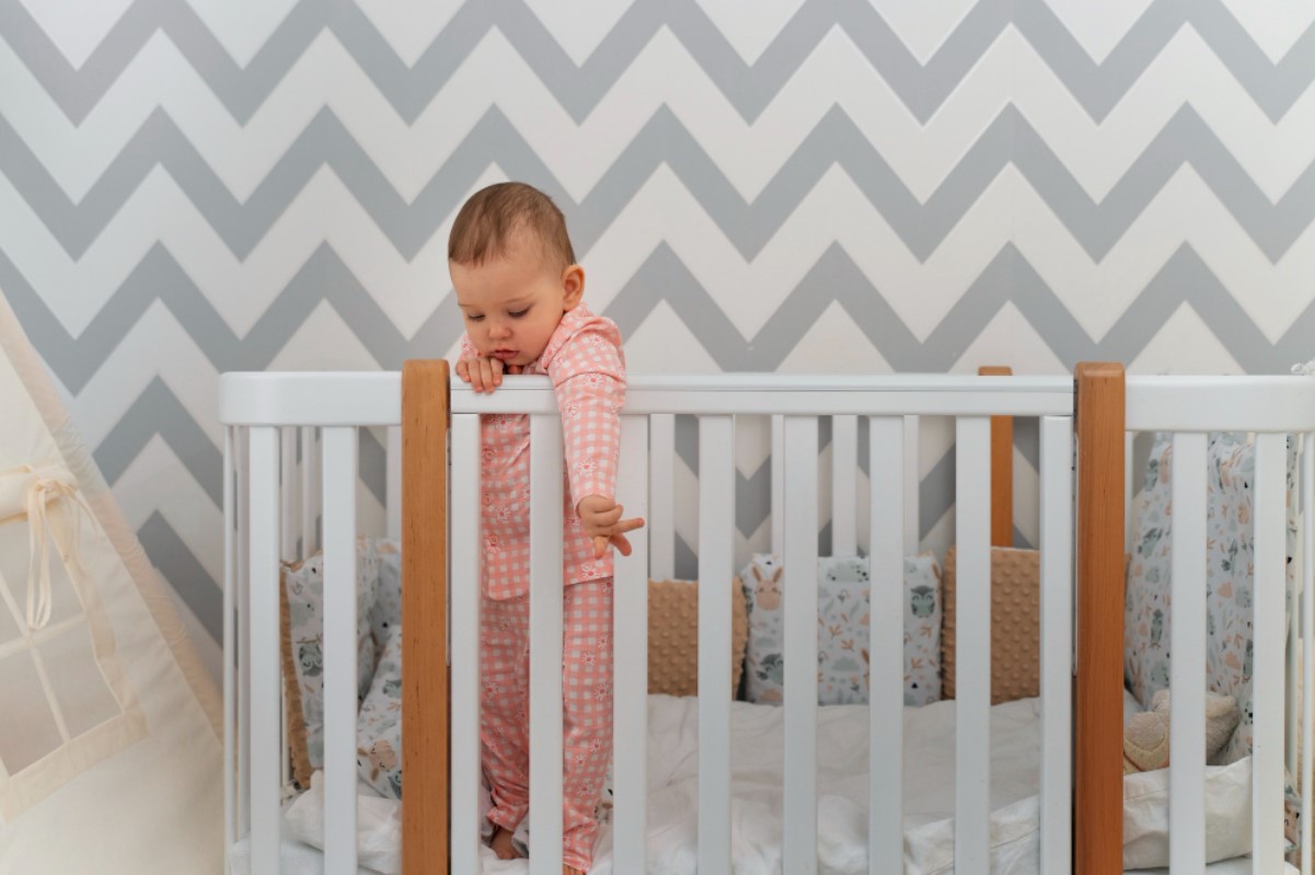 Toddler standing inside a white crib.