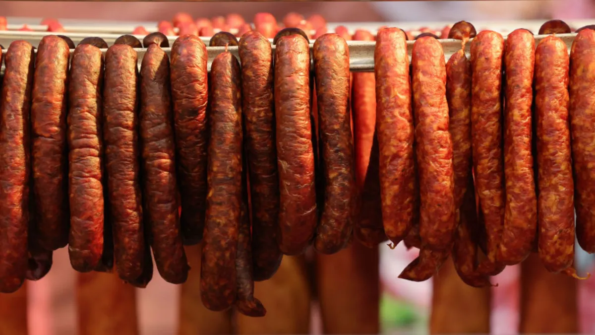 Several red sausages hanging from a line