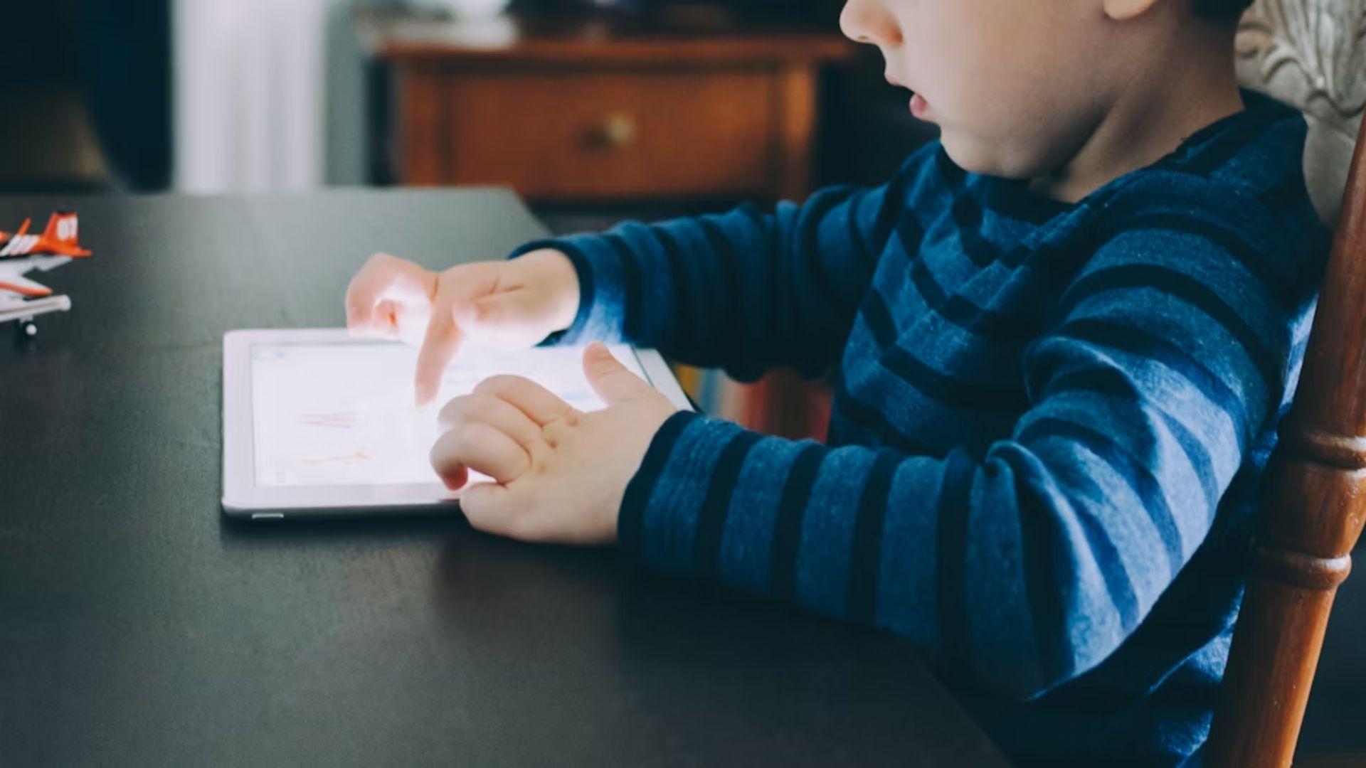 A child using a tablet; illustrative archive photograph, not an identified participant in the report.