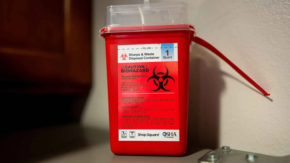 Close-up of a home sharps container for disposal of medical waste and syringes