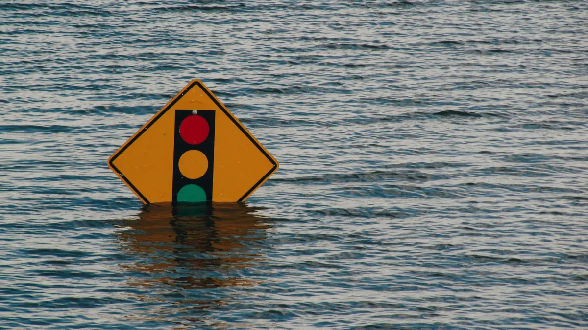 A traffic sign almost completely submerged by water during a flooding event.
