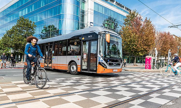 A cyclist and public bus in a street; illustrative archive photograph.