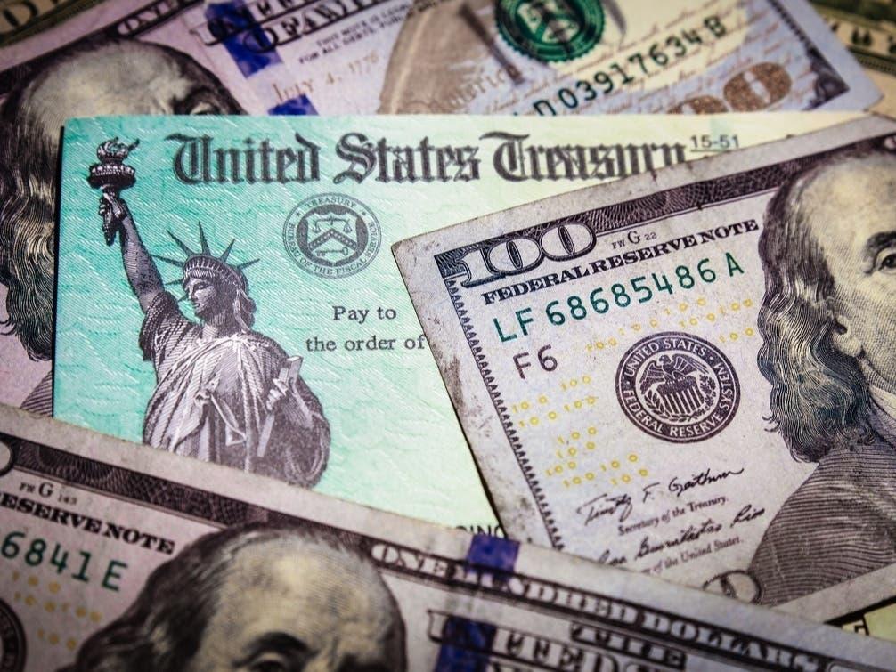 Cash and a U.S. Treasury check; illustrative archive photograph.