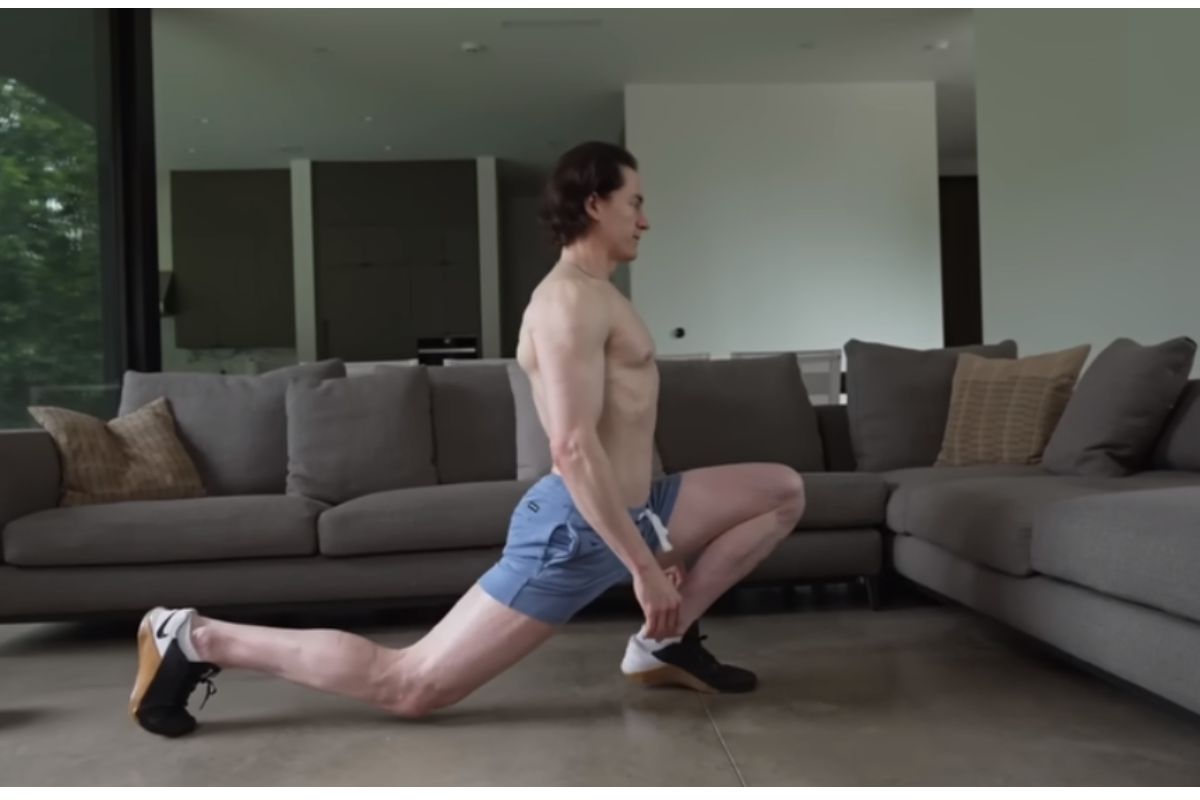 Bryan Johnson stretching beside a couch