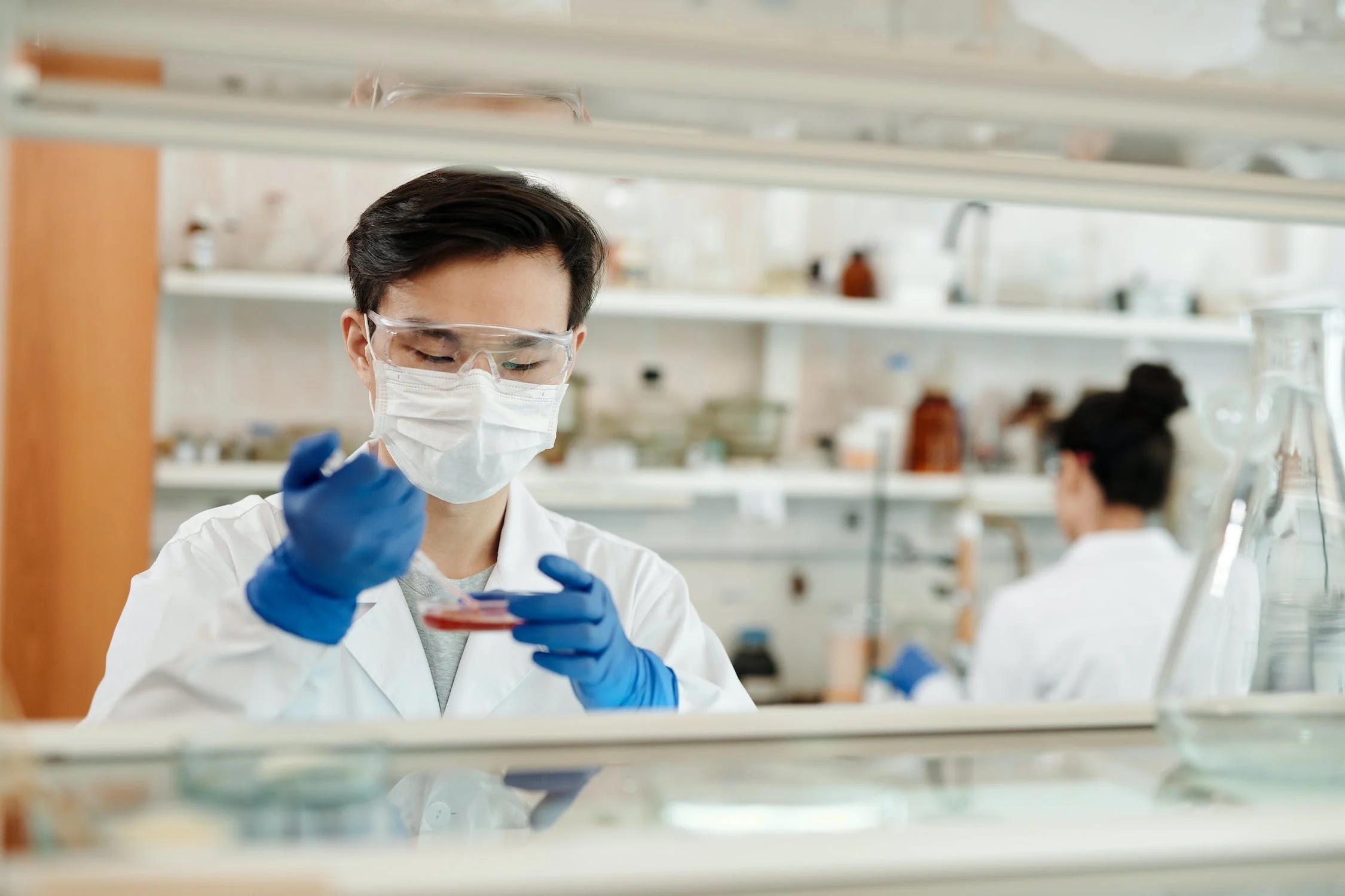 A laboratory worker using a pipette