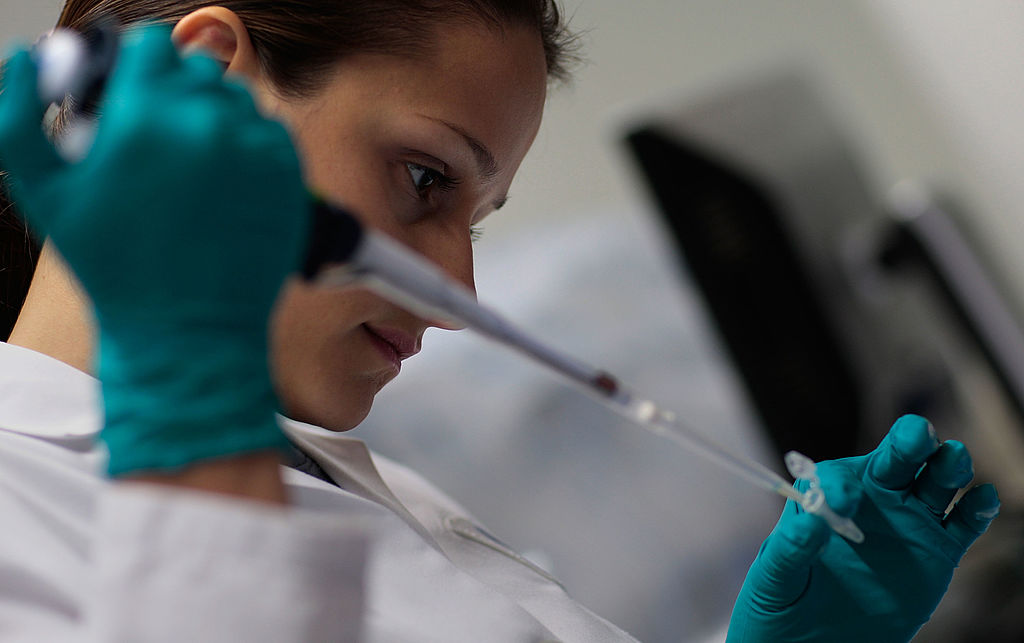 A laboratory worker using a pipette, an illustrative photograph
