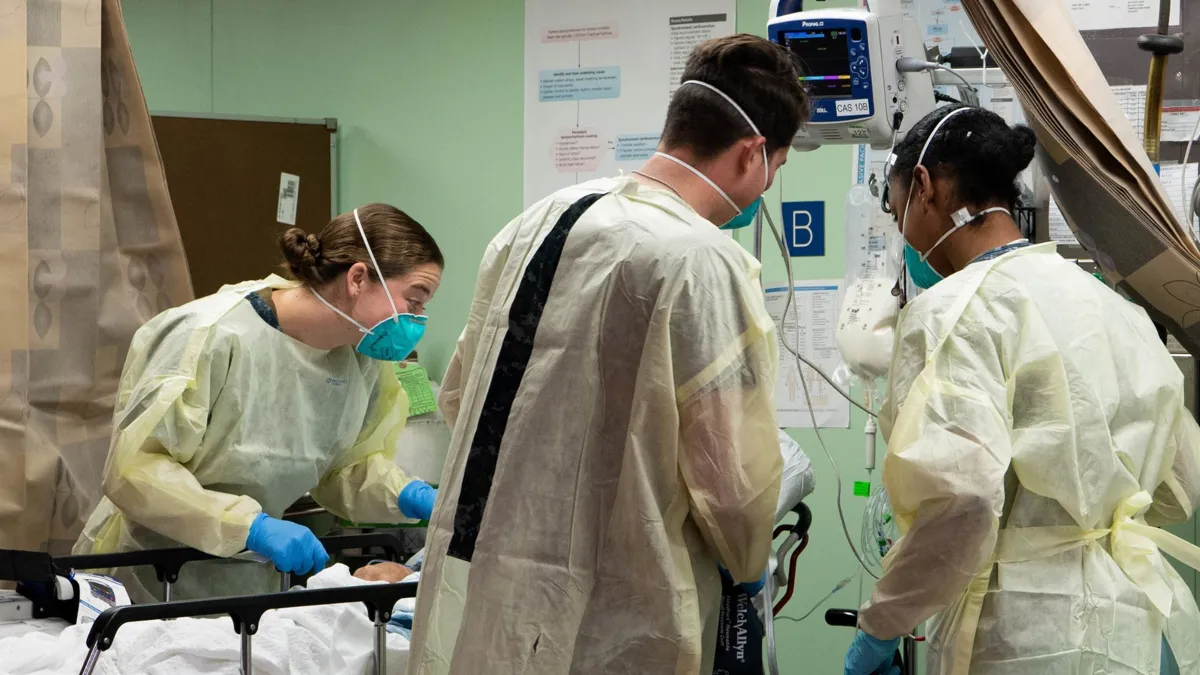 California health workers helping a patient in a hospital during the COVID-19 pandemic.