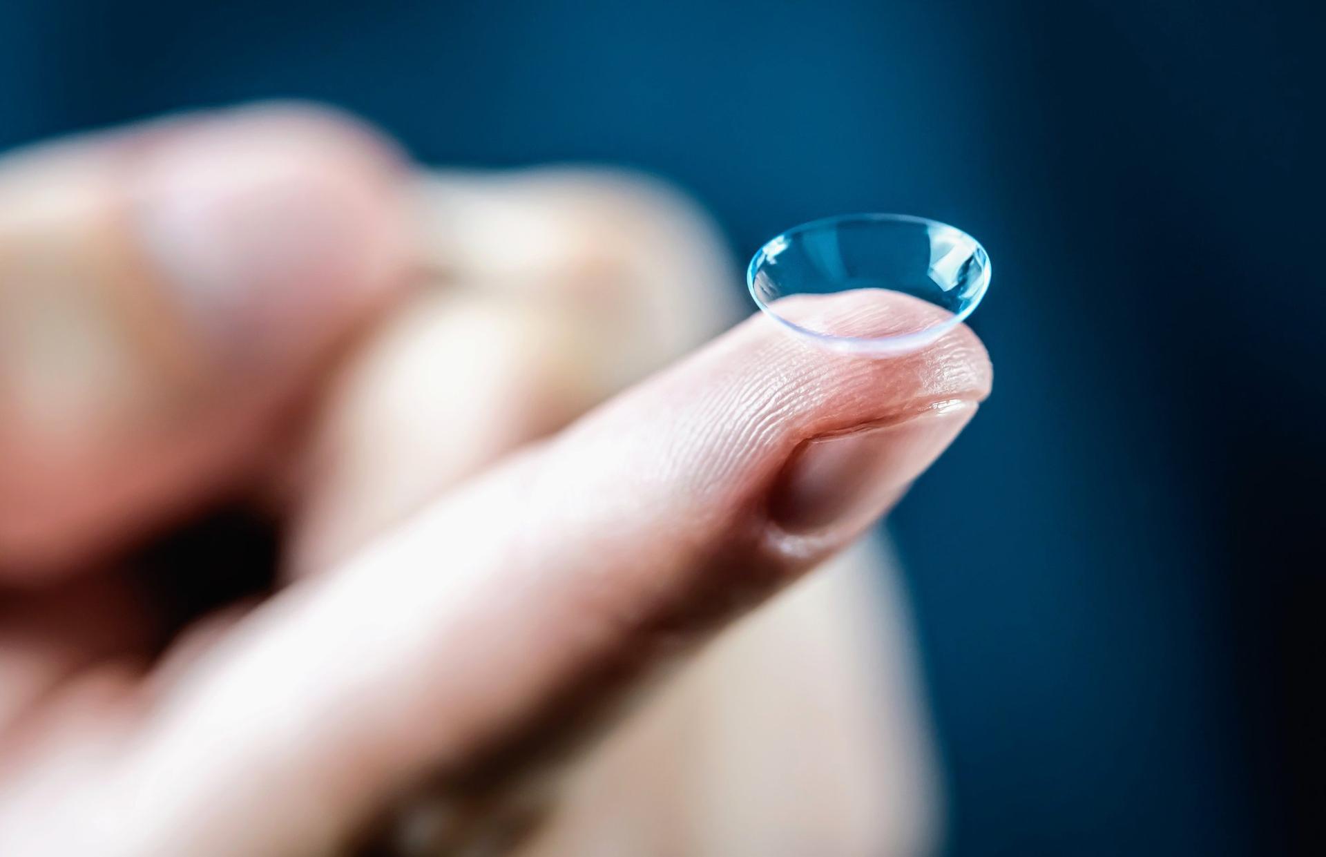 A contact lens on a fingertip; illustrative archive photograph, not a tested product.