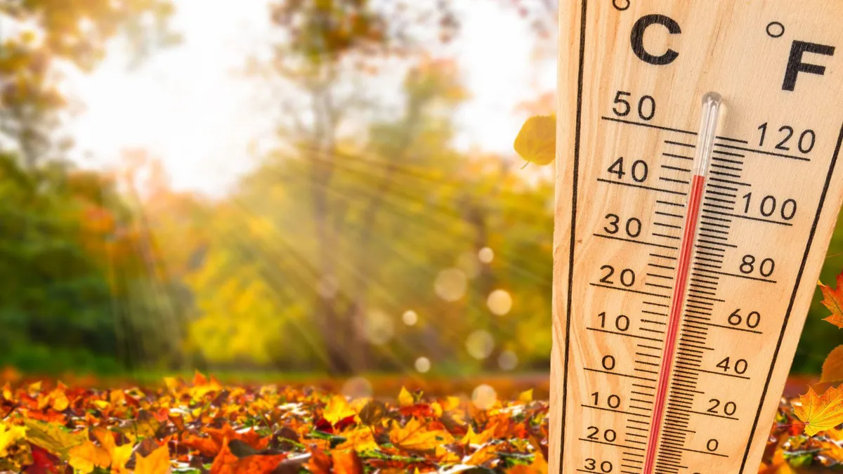 The sun shines on a warm autumn day/A thermometer showing over 100-degree temperature