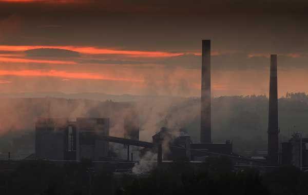 Industrial chimneys at sunset; illustrative archive photograph.