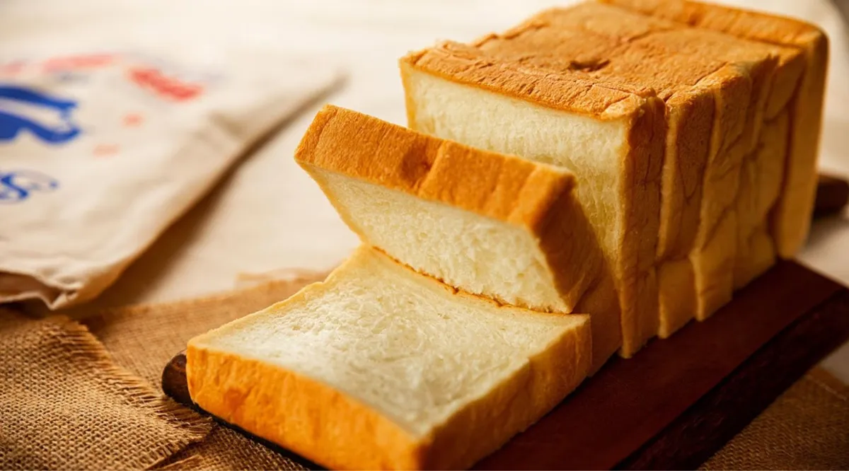 Some white bread cut up on a board.