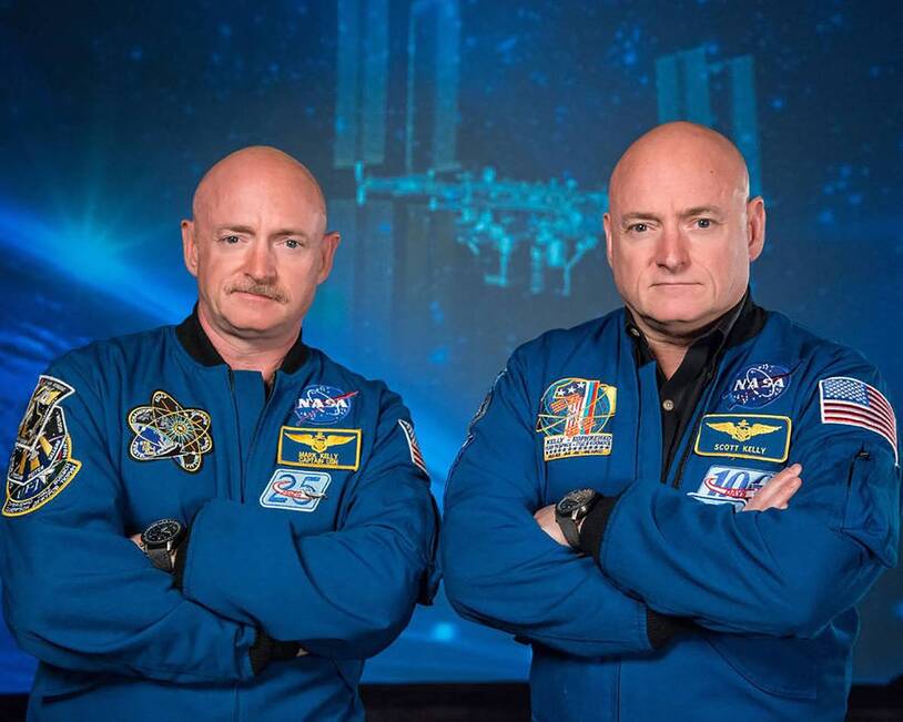 Scott and Mark Kelly in blue NASA flight suits