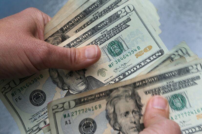 Hands holding banknotes; illustrative archive photograph.