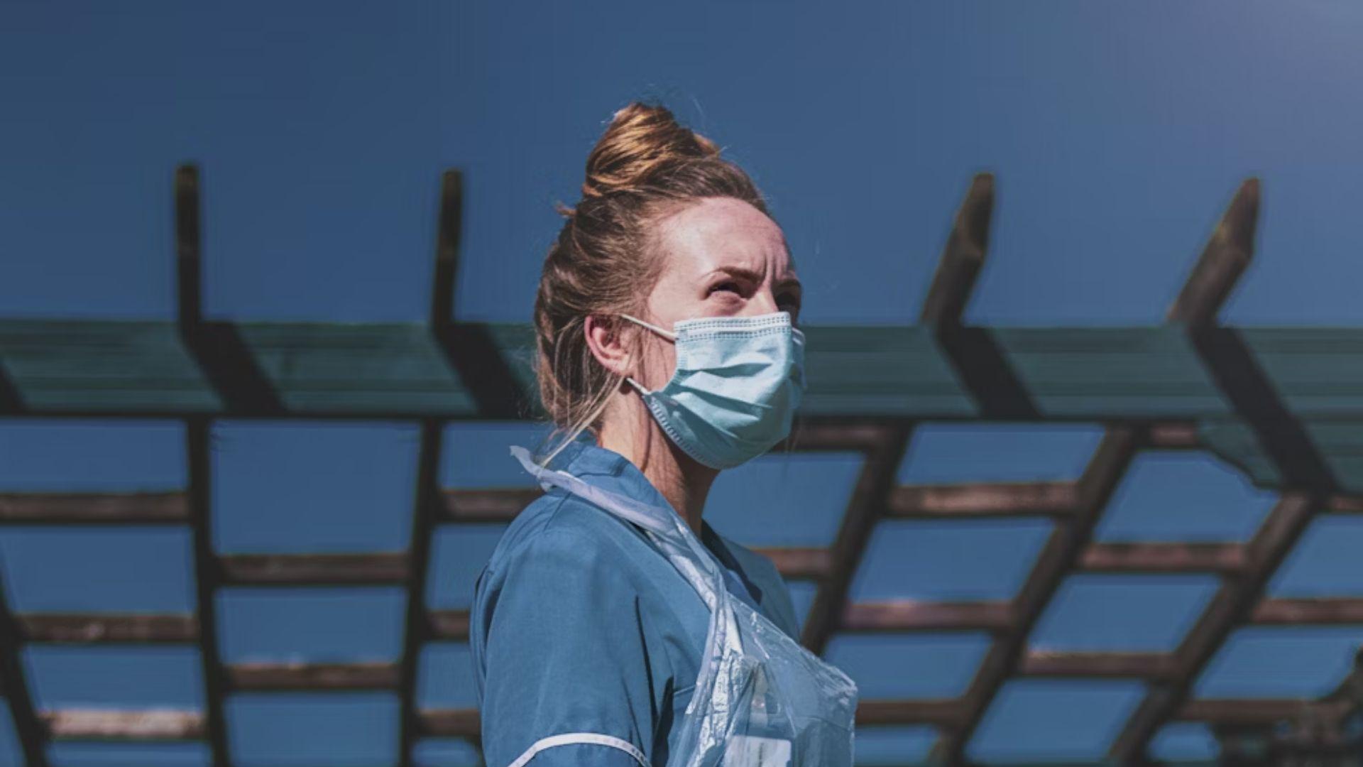 A masked clinician outdoors; illustrative archive photograph.
